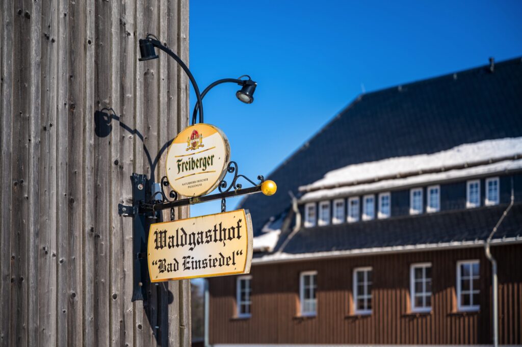 Zu sehen sind 2 Schilder mit Waldgasthof Bad Einsiedel und Freiberger Biere.